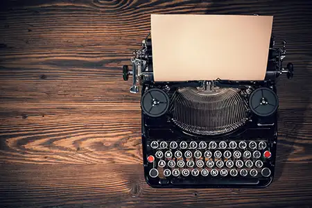 A typewriter sitting on a wooden surface