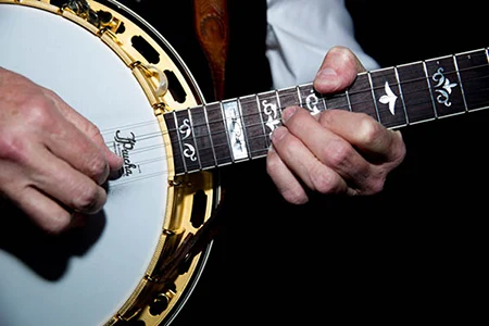 Close-up of a man's hands playing a banjo